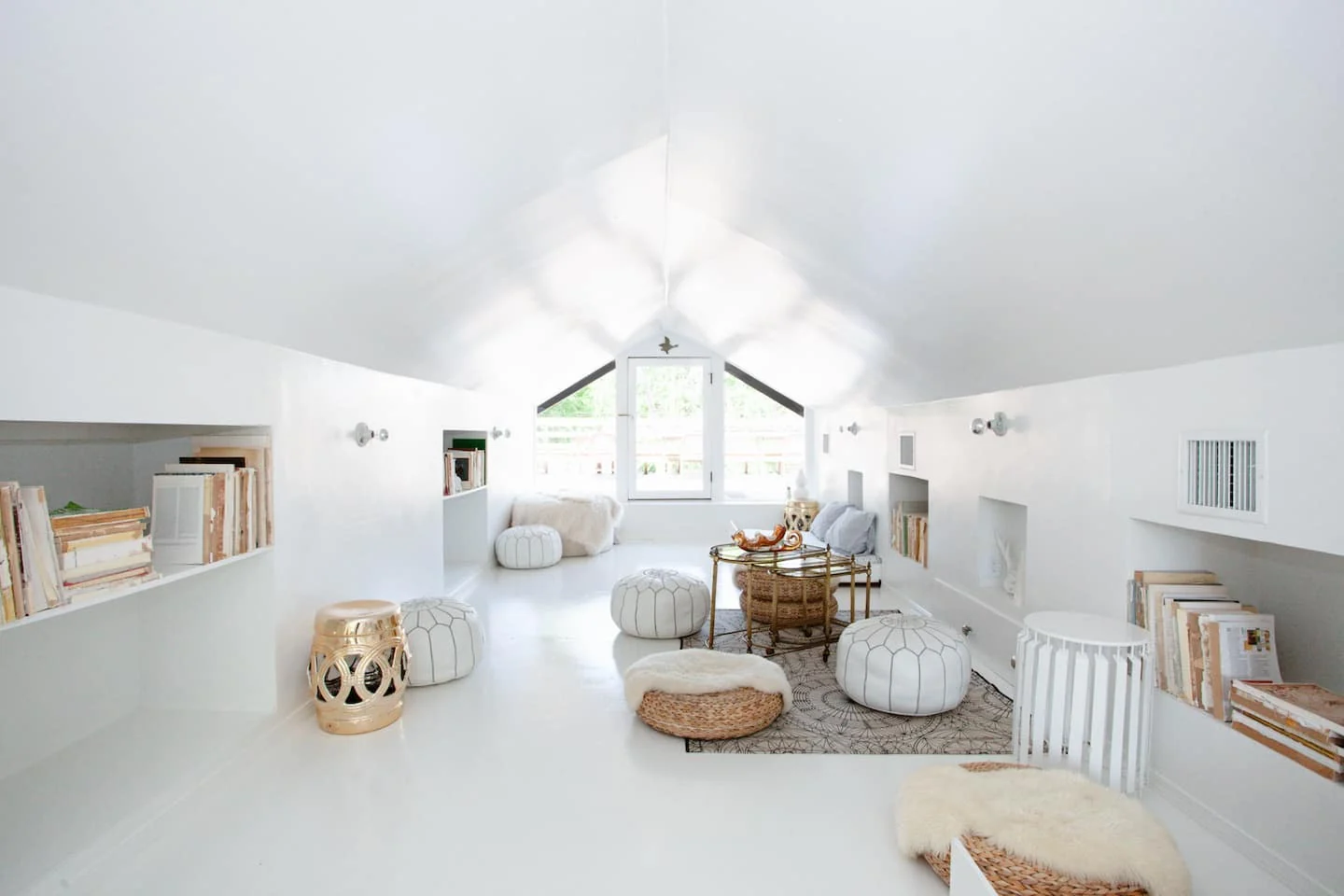 Bright loft lounge with white seating and a pitched ceiling — 2nd St, Austin, Texas