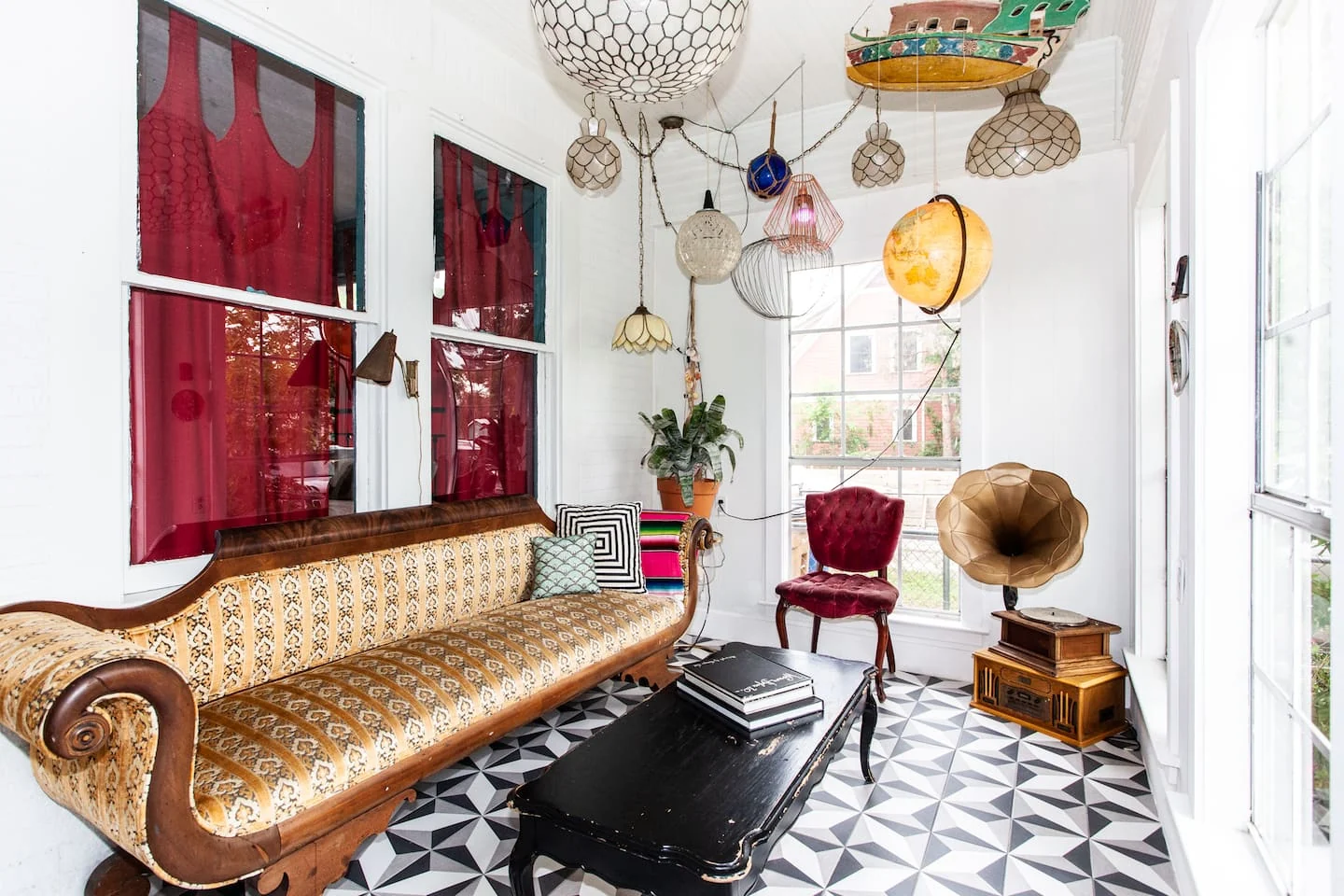 Eclectic sitting room with a gold vintage sofa, graphic floor and hanging objects — 2nd St, Austin, Texas