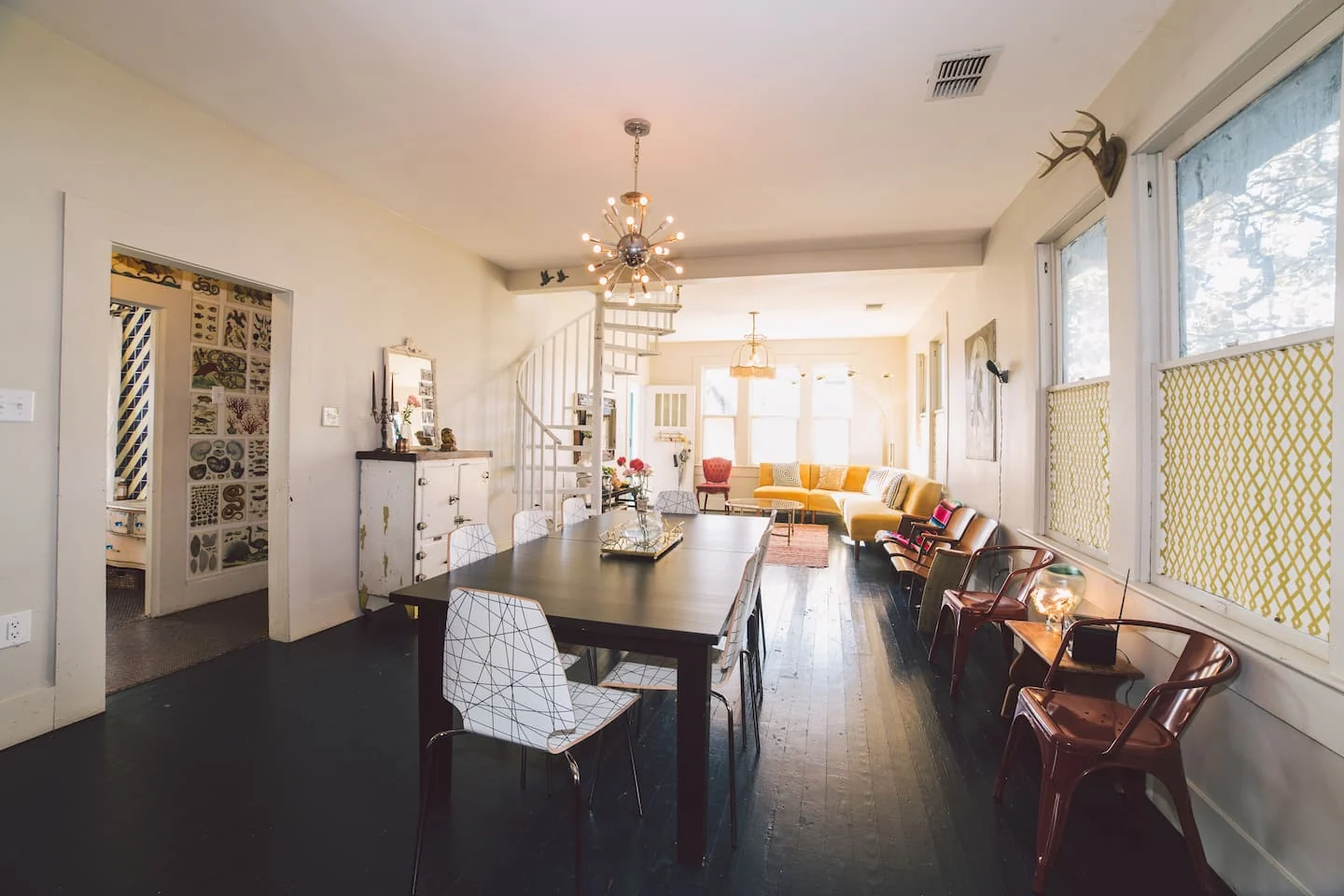 Open dining and living space with dark floors and a chandelier — 2nd St, Austin, Texas