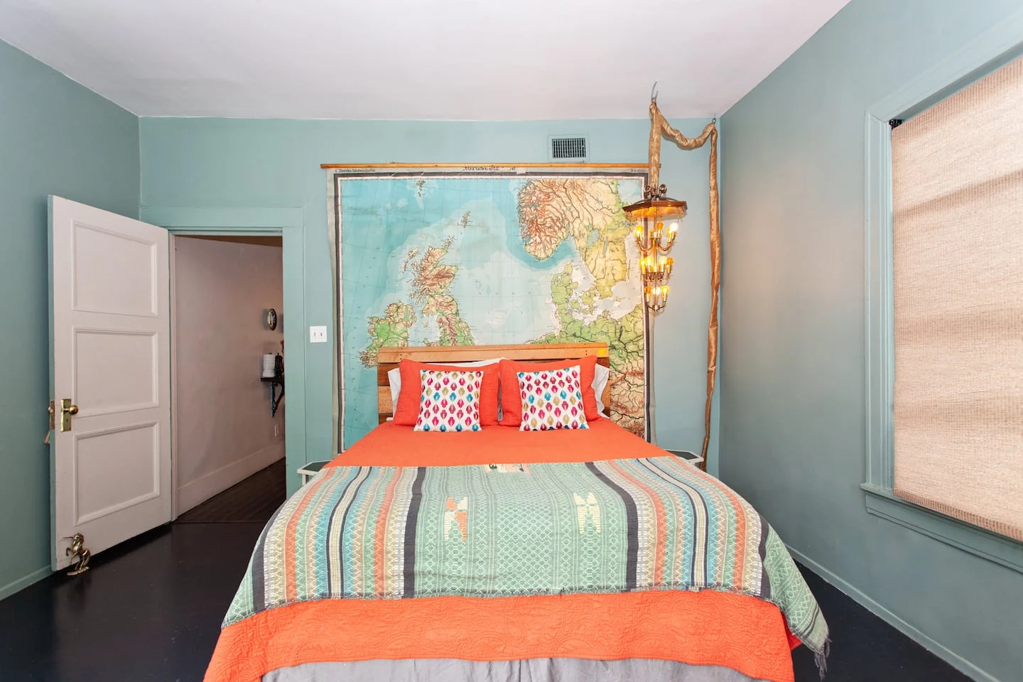 Pale blue bedroom with a striped quilt and vintage wall accents — 2nd St, Austin, Texas