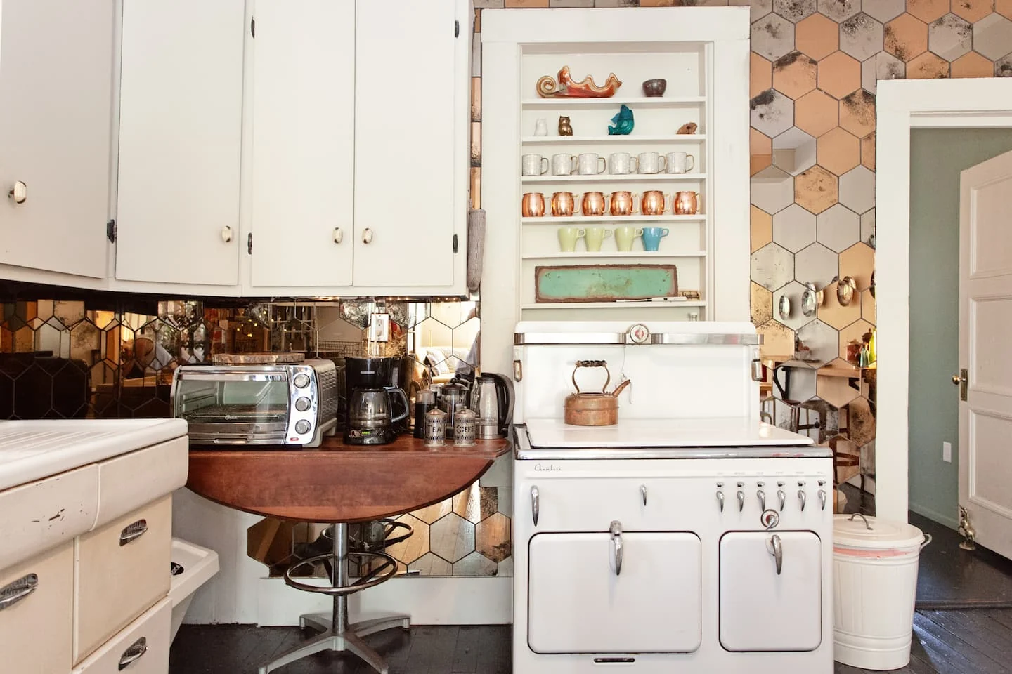 Vintage kitchen with white cabinets and botanical wall details — 2nd St, Austin, Texas