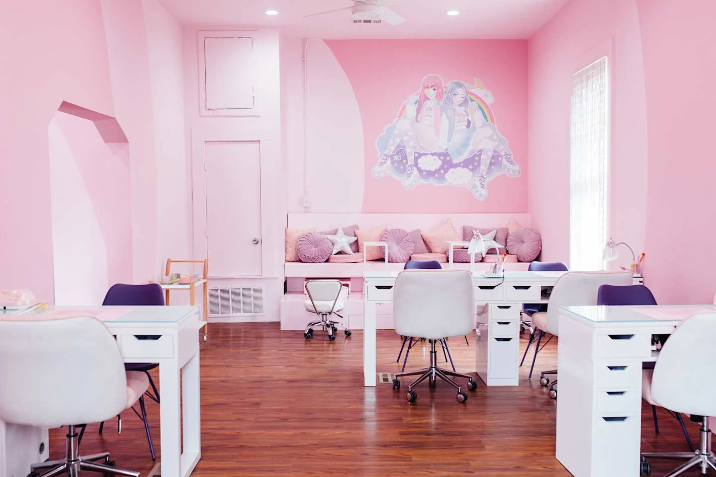 Pink manicure room with white chairs and colorful wall art — Cute Nail Studio, East Austin, Texas