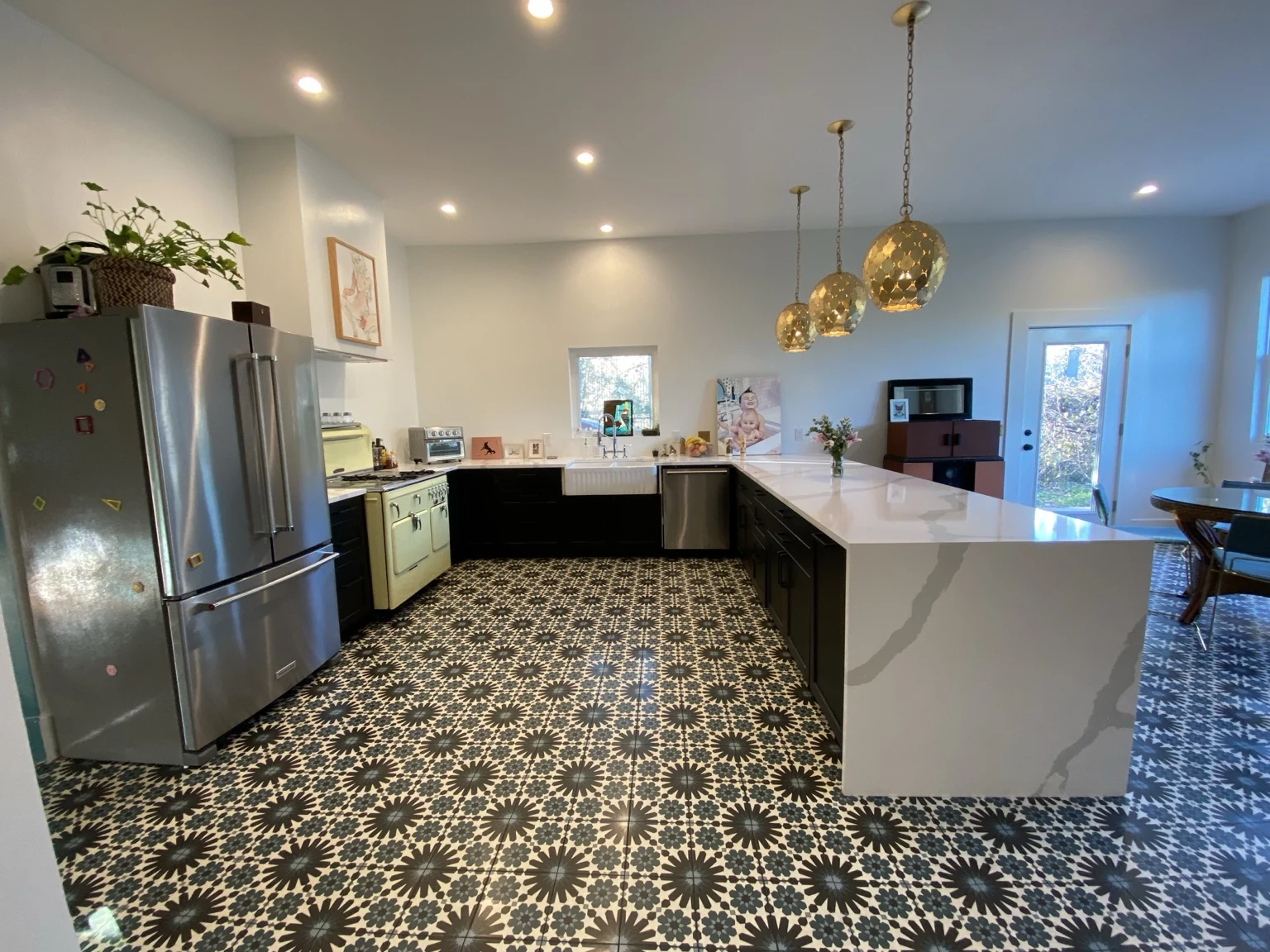 Kitchen with a white waterfall counter, vintage range and black-and-white patterned floor
