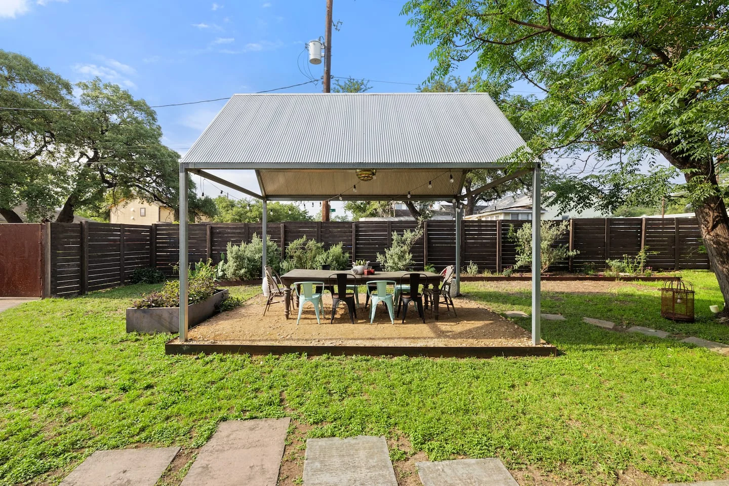 Backyard dining pavilion surrounded by grass and mature trees — Navasota, Austin, Texas