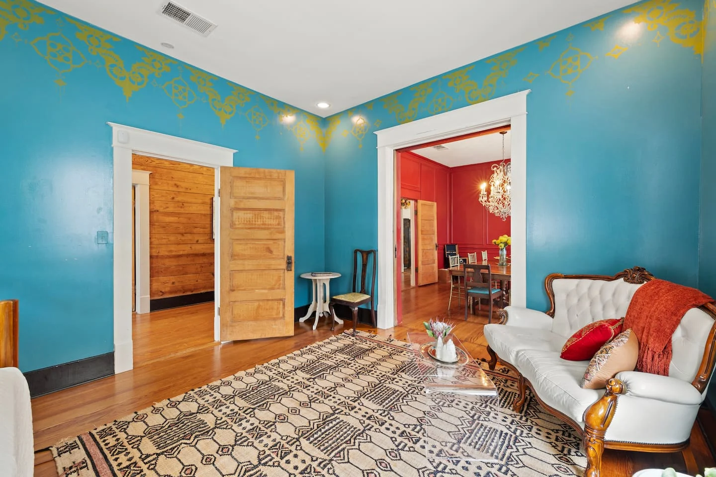 Blue sitting room with gold accents and a vintage white sofa — Navasota, Austin