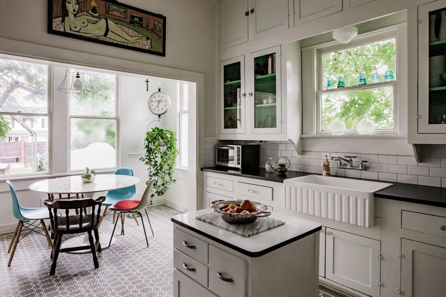 White kitchen with an island and sunlit breakfast table — Navasota, Austin