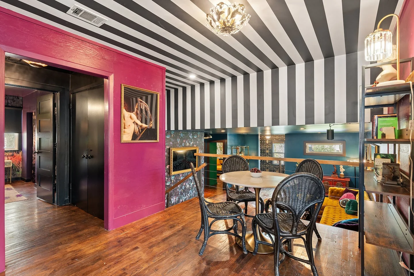 Dining area with a striped ceiling, round white table and deep pink walls — Oak Springs, Austin, Texas