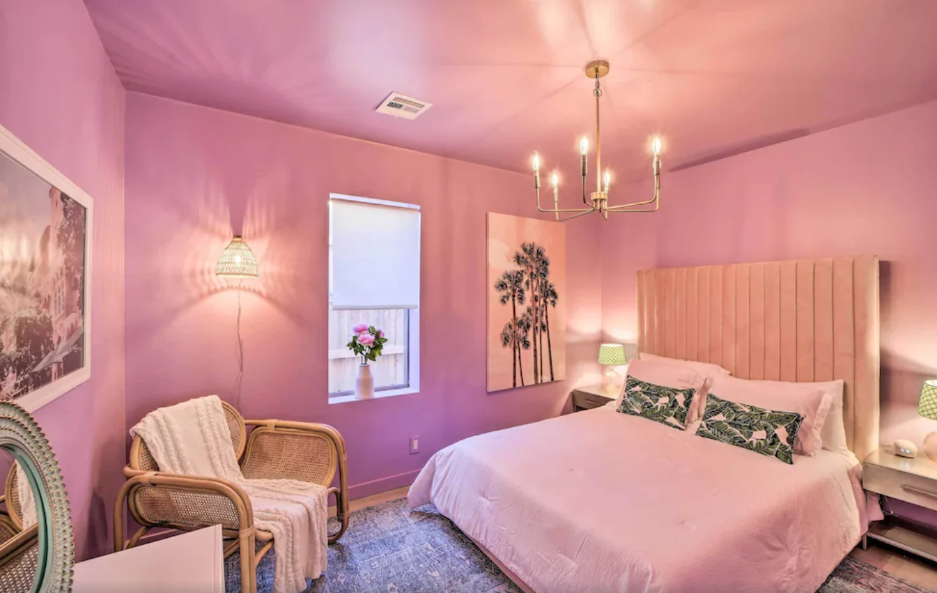 Pink bedroom with an upholstered headboard and tropical-print pillows — Tulsa Birdcage, Tulsa, Oklahoma
