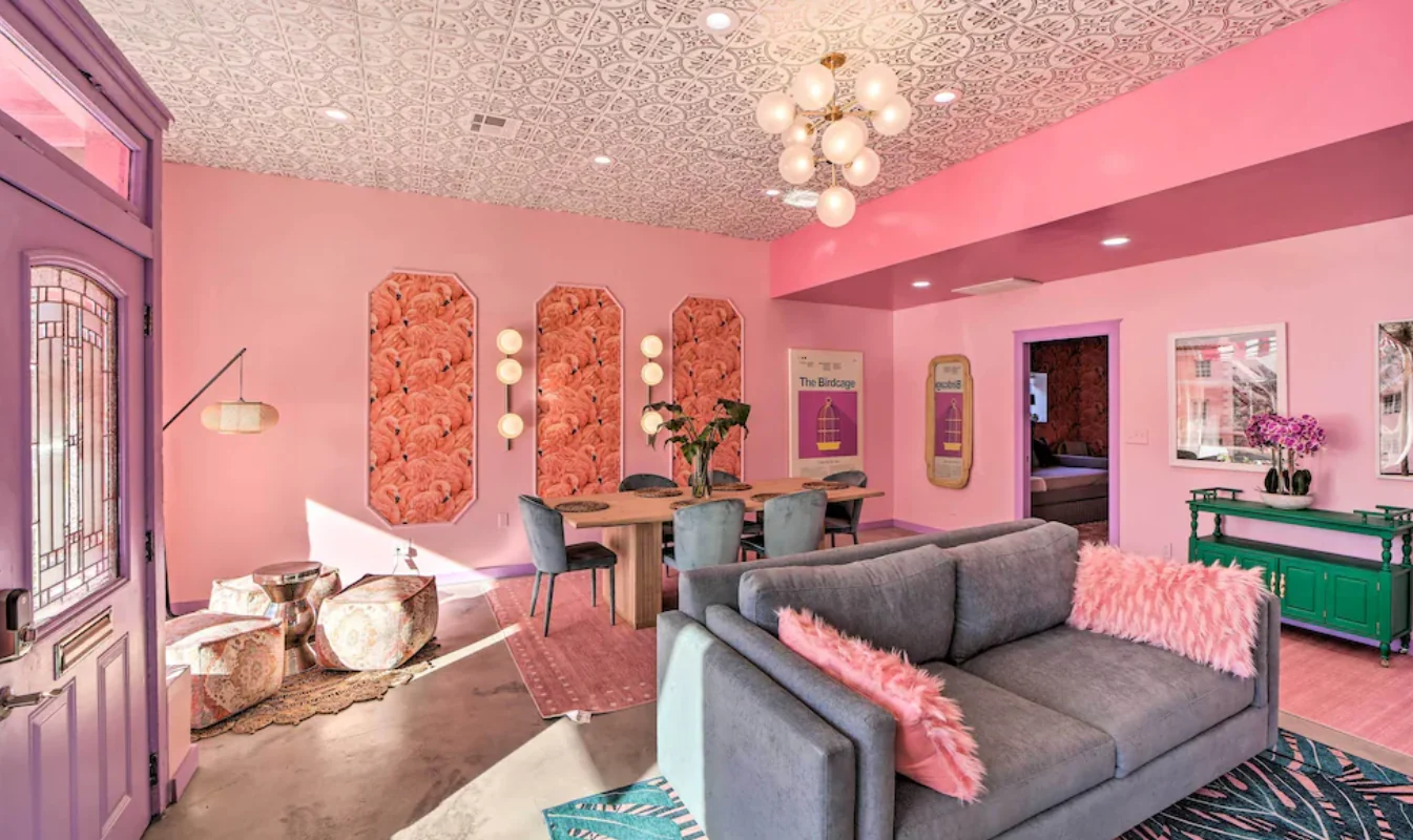Pink living room with a gray sectional, sculptural ceiling lights and turquoise accents — Tulsa Birdcage, Tulsa, Oklahoma