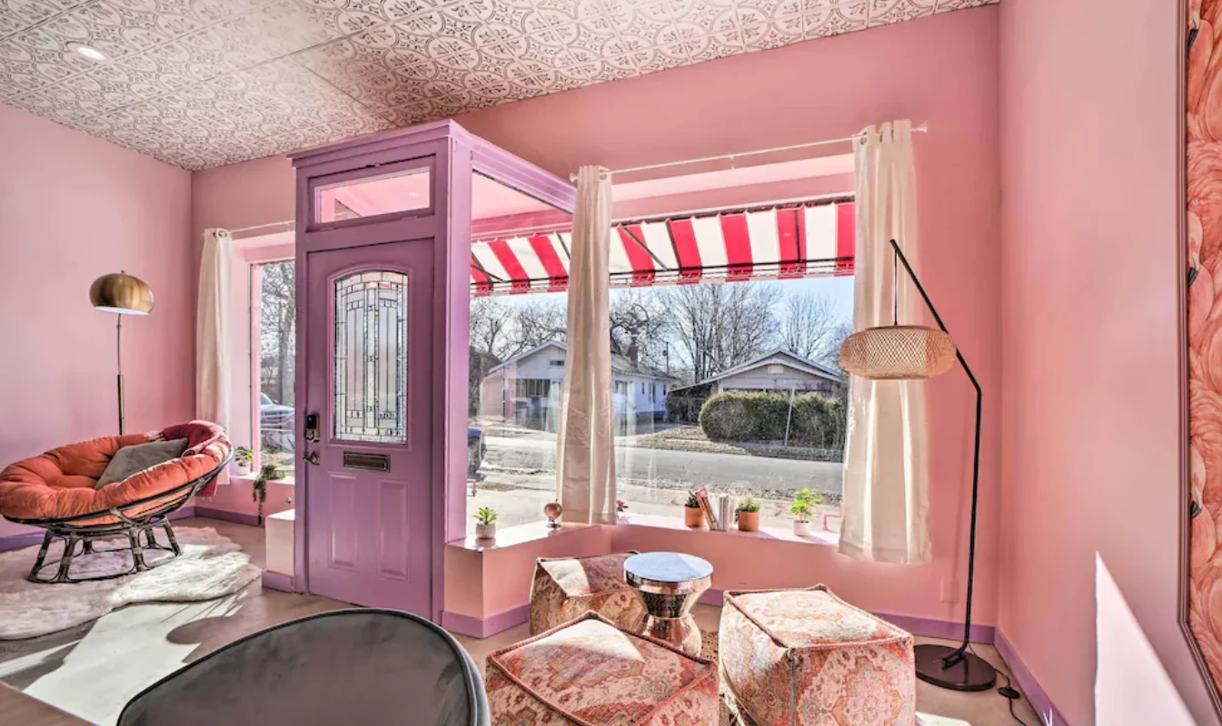 Sunlit pink lounge with large windows and a striped awning — Tulsa Birdcage, Tulsa, Oklahoma